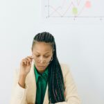 Focused businesswoman studying financial charts at desk.