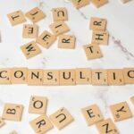 Scrabble tiles spelling 'Consulting' on a stylish marble surface symbolize strategic creativity.